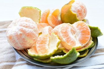  Natural, whole, chopped tangerines on wooden background