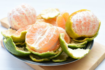  Natural, whole, chopped tangerines on wooden background