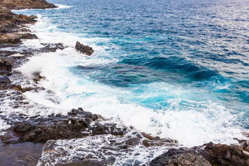 ocean waves hit and crash against stones