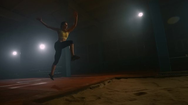 The camera follows the jumping athlete in slow motion. Professional sports long jump