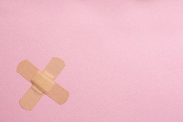 Sticking plasters on pink background, top view. Space for text