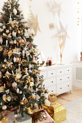 Concept of Christmas decoration for the house, horse on the background of a Christmas tree, bokeh, garlands, white chest of drawers, children's room with toys and gifts, living room interior