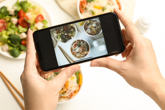 Blogger taking picture of lunch at table, top view