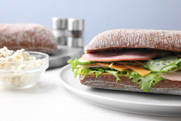 Tasty sandwich with ham on white wooden table, closeup