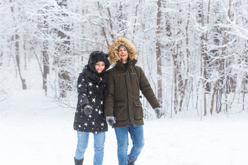 Fototapeta premium Happy loving couple having fun outdoors in snow park. Winter vacation