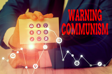 Conceptual hand writing showing Warning Communism. Concept meaning economic system where the group...