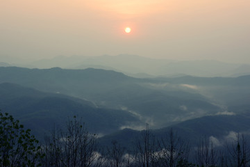 Sunrise among mountains and fog