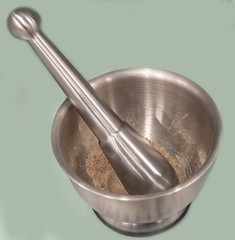 ground spices in a stainless steel mortar