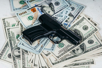 Detail of gun with bullet on US dollar 100 bill banknotes