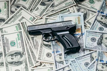Detail of gun with bullet on US dollar 100 bill banknotes