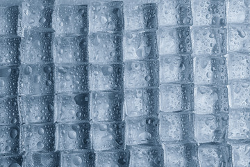 Crystal clear ice cubes with water drops as background, top view