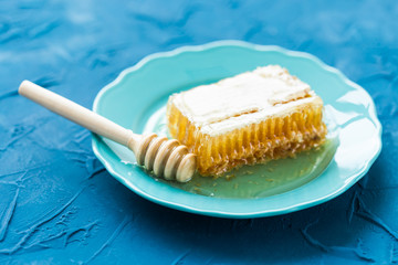 Honey with wooden honey dipper and honeycombs