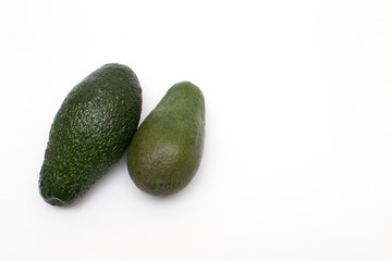 two ripe avocados on a white background, there is copy space