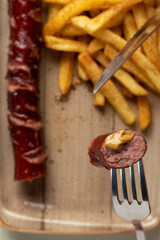 Fried sausage with french fries served on plate