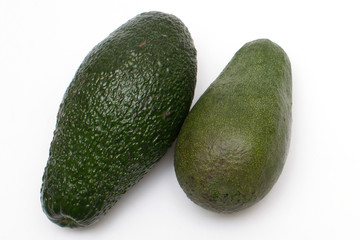 two ripe avocados close-up on a white background