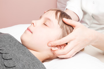 Fototapeta na wymiar Girl receiving osteopathic treatment of her head