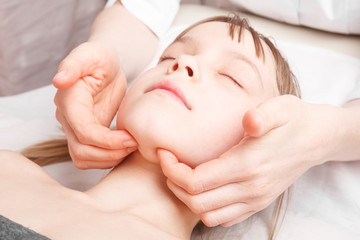 Girl receiving osteopathic treatment of her jaw