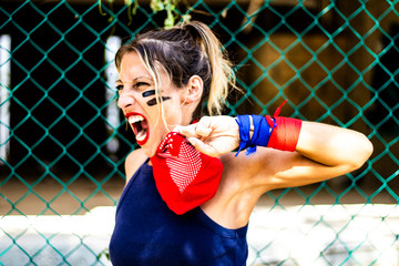 Profile view and close up on a strong and young woman with red bandana screaming for human rights,...