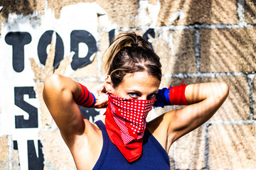 Close up on beautiful and strong young caucasian blond woman looking the camera while tying her red...
