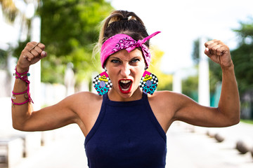Close up on gorgeous strong young woman in retro pin-up style raises her arms in the air, shows her...
