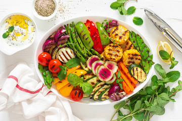 Grilled vegetables on a white plate, top view
