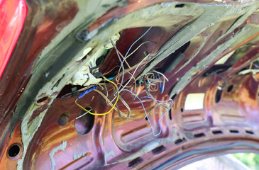 Old broken car. Rusty trunk. Electrical wires need repairing.