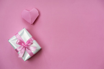 Monochromatic pink Valentine's background with a gift box and origami heart.
