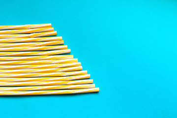 
Straw of yellow juice on a blue background