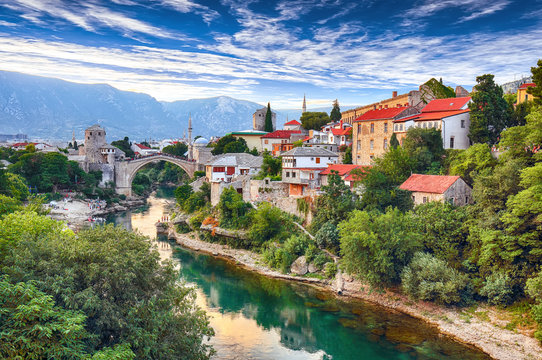 Fantastic Skyline of Mostar with the Mostar Bridge, houses and minarets, during sunny day.