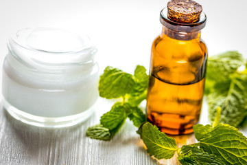 organic cosmetics with herbal extracts of mint on wooden background