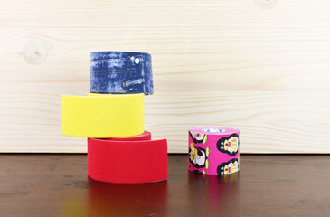 Special kinesiology tape rolls and colorful therapy tools on a wooden background, Physiotherapy...