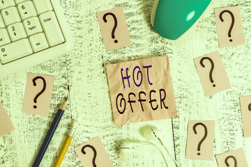 Conceptual hand writing showing Hot Offer. Concept meaning product or programme that is offered at reduced prices or rates Writing tools and scribbled paper on top of the wooden table