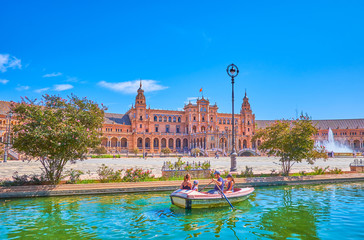 The family sails in Plaza de Espana in Seville, Spain