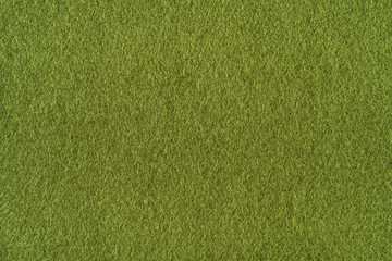 Green olive background from a soft wool textile material closeup. Fabric with natural texture.