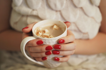 Female hands with coffee drink, knitted sweater