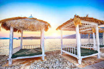 Thatched canopies and awnings on the beach Copacabana at sunset in Dubrovnik