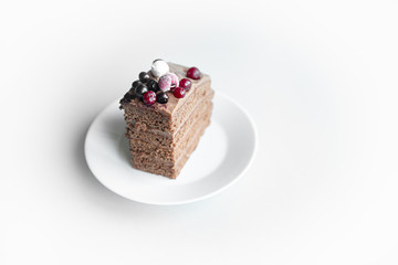 White plate with chocolate pie of homemade cake with berry decorate on top