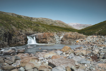 Closeup of a waterfall in a rocky environment on Island of kuannit, Disko Island in Greenland.