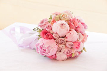 beautiful bouquet of peonies and other pink flowers with wedding rings for newlyweds