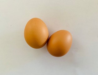 two brown eggs isolated on white background