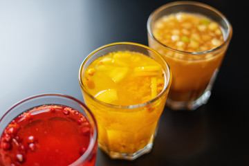 Three teas from different berries and fruits on a black table in a cafe, bar or restaurant.