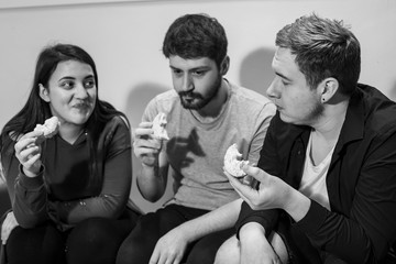 Two mates eating a doughnut in a canteen in Carlisle University.