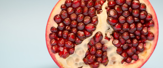 Half pomegranate on a blue background. Close-up