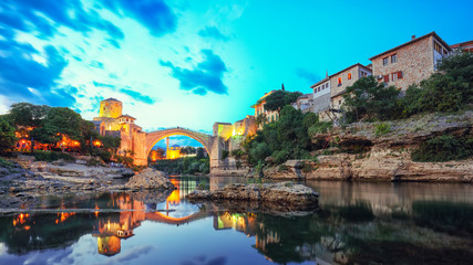 Majestic evening view of Mostar with the Mostar Bridge, houses and minarets, at evening