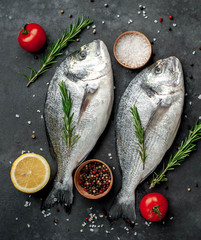 Fresh dorado fish with spices and ingredients tomato, razmorin, sunflower oil, lemon for cooking on...