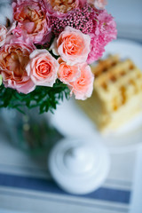 Delicate bouquet of eustomas, carnations, cotton, spray roses and roses David Austin, in pink and beige colors on a background of plates with waffles - 318668650