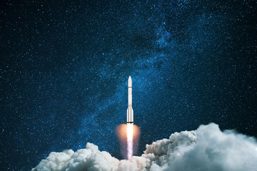 Rocket starts in the night starry sky. A spaceship flies into outer space. Concept of travel to...