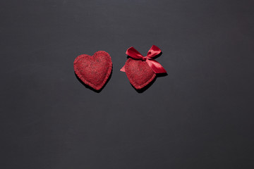 two hearts on a black background, bow on one, concept of couple, love, declaration of love, surprise for St. Valentine's Day