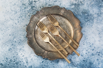 Old bronze forks on vintage dish