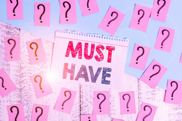 Text sign showing Must Have. Business photo showcasing something modern that analysisy showing want to have Essential item Scribbled and crumbling papers with thick cardboard above wooden table